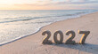 © Parvej - The year 2027 written in sand on a tropical beach during a beautiful golden sunset background