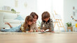 © tonefotografia - Mom Reads a Book With Her Children on the Floor in a Bright Living Room