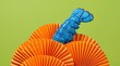 © ADDICTIVE STOCK - Blue lobster tail emerging from orange paper fan sculpture