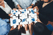 © InfiniteFlow - A diverse group of professionals engaging in collaborative teamwork, assembling puzzle pieces that symbolize critical business strategies and solutions in a corporate setting. Amity