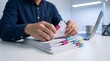 © IQBAL HOSEN - A professional man sitting at a desk organizing a stack of business documents with colorful index tabs for easy reference