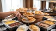 © CuteBee - Person using metal tongs to select fresh croissant from hotel breakfast buffet display with various pastries and warm dishes arranged in background for guests in bright dining hall