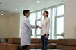 © Stock Media Labs - Doctor greeting female patient with handshake during medical consultation in modern clinic with female patient with female patient