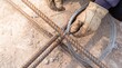 © BlackBridge Media - Worker Tying Steel Rebar with Wire on Construction Site