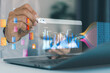 © MUNTHITA - Businessman analyzing financial data dashboards on laptop with virtual analytics interface, AI technology, KPI metrics, big data visualization, digital transformation, business intelligence.