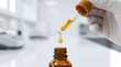© Asma - Scientist in white gloves dropping golden serum into amber glass bottle in laboratory, closeup macro shot representing skincare beauty oil formulation, medical healthcare research, clinical treatment