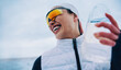© Jacob Lund - Joyful woman hydrating during snowy winter running session