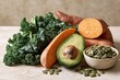 © FranKissStudio - Fresh organic ingredients including sweet potatoes, curly kale, avocado, and raw pumpkin seeds