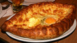 © Svetlana - Traditional Adjarian khachapuri, boat-shaped Georgian bread filled with melted cheese, egg yolk and butter, freshly baked and served hot.