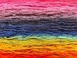 © Linda - Full frame texture of colorful rainbow yarn threads for knitting and crafting. Bright multi-colored wool fiber background for handcraft, textile art, and needlework projects.
