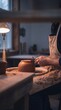© AdPremium - Professional potter trimming the bottom of a clay bowl on a spinning pottery wheel in a cozy rustic art studio workshop