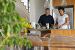 © WavebreakMediaMicro - Senior couple preparing drinks and food at kitchen island with blender, plant, dining table