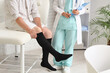 © Pixel-Shot - Compression therapy and vascular health, patient wearing medical stockings during a consultation with a doctor in a clinic for venous disease treatment