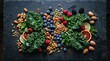 © pengedarseni - Fresh kale leaves, assorted raw nuts, and vibrant berries arranged centrally on a textured black slate stone surface for a healthy food composition.