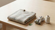 © Munny - Folded beige knitted sweater with fabric scraps and twine on a light