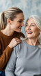 © Mirivox - Two smiling women, one older with grey hair and one younger with blonde hair, share a tender moment, symbolizing generational connection and love, perfect for lifestyle or family themes
