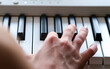 © Elena - Kid girl hand on digital piano keyboard closeup. Child practicing at home