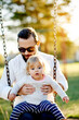 © peopleimages.com - Nature, swings and dad with kid in park for holiday, weekend or vacation together. Smile, trees and girl child with father for playing outdoor on playground for connection in summer in backyard.