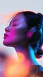 © Daria - Profile of a young woman with closed eyes enjoying immersive music with wireless headphones highlighted by colorful vibrant lighting effects