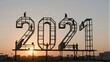 © joeycheung - Workers assemble giant 2021 numerals at sunset, symbolizing new year's arrival.
