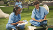 © DC Studio - Medical students fist bump beside laptop on grass
