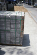 © Bowonpat - Stacked granite paving slabs bound with straps on street sidewalk.