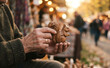 © SimpleDesignStudio - Elderly man holding a handcrafted wooden squirrel figurine at an outdoor artisan market autumn fair
