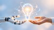 © Annisa - Technology innovation concept showing human and robot hands holding a glowing digital light bulb symbolizing futuristic creative solutions