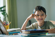 © Westend61 - Smiling boy studies his school lessons at an indoor desk