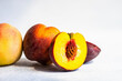 © Foodlovers - Ripe peaches with halved peach showing seed and yellow flesh