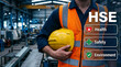 © Sara moni - Industrial worker holding a hard hat with health safety and environment graphics