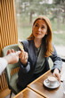 © Novak - Businesswoman handing credit card for payment at cafe table