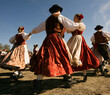 © Masha - Standard Bavarian couples executing an upbeat folk dance in vibrant attire at an open-air festival