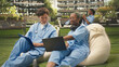 © DC Studio - Diverse med school peers in blue scrubs collaborate with laptop notes