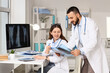 © Pixel-Shot - Medical diagnosis and healthcare collaboration, doctors reviewing patient chest x-ray results in a modern hospital office with digital imaging technology