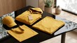 © RisaFitri - Mustard Yellow Apparel Branding Mockup Featuring Folded Hoodie with Blank Price Tag, T-shirt, Baseball Cap, and Tote Bag on a Reflective Black Table in a Minimalist Modern Studio Interior Setting