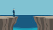 © Deck - Businessman in a sharp suit standing on a cliff edge looking across a dangerous gap toward success.