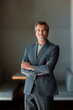 © OchreOchre/Stocksy - Confident Businessman In Suit Standing With Arms Crossed