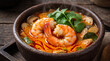 © Laliya - Authentic Thai Tom Yum Goong spicy shrimp soup in a rustic stone bowl