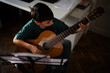 © Zoran Jesic - Young boy learning playing classical guitar music