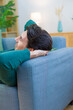 © Metadancer - White man resting on a couch in a modern living room
