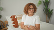 © Krakenimages.com - Woman holding document and touching forehead while seated on bed in building; concern reflection solitude.