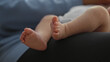 © Krakenimages.com - Newborn boy feet being gently touched and played with by adult hand on lap in home; parental bonding tenderness.