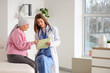 © Pixel-Shot - Senior woman after chemotherapy with pink ribbon visiting doctor in clinic. Breast cancer awareness concept