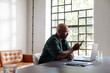 © Martin Sarovski/Stocksy - Businessman Working Remotely at Laptop and Phone