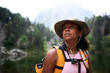 © CarlosBarquero - A Latina African American woman looks to the side in a hiking portrait with a forested mountain lake behind her. Photographed in the Aiguestortes area of the Spanish Pyrenees.