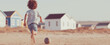© Bonsales - Young child is enjoying a game of soccer on a sandy beach, energetically running barefoot and kicking a ball among vibrant wooden houses