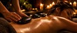© Nikolay - Panoramic view of professional stone therapy with masseur hands placing hot basalt stones on young woman oil wet back in cozy spa room with burning candle lights bokeh, luxury wellness banner