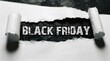© robiul - Black friday text revealed through torn white paper showing a dark textured background