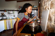 © Alvaro Lavin/Stocksy - Young woman cooking in kitchen smelling food aroma